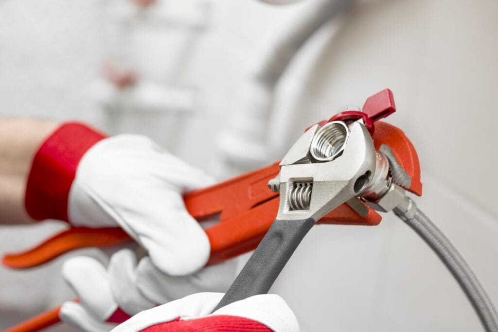 Plumber holding pipe wrenches for an emergency repair in Miami Gardens