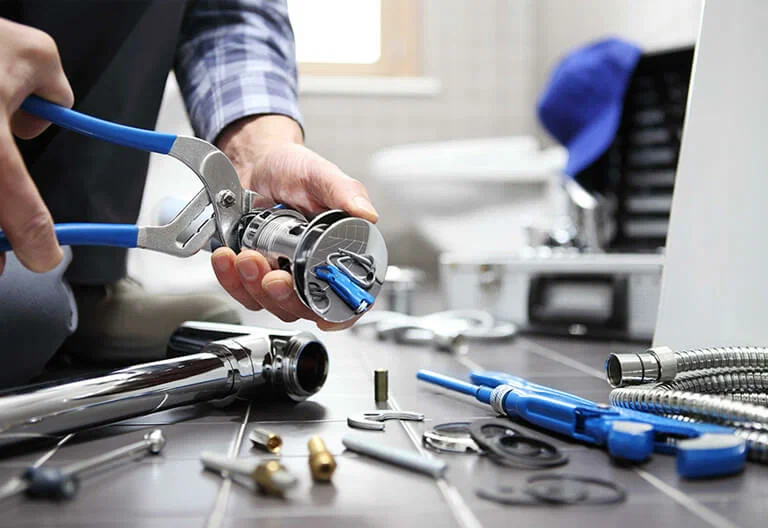 Technician repairing a plumbing fixture with professional tools in Miami Gardens