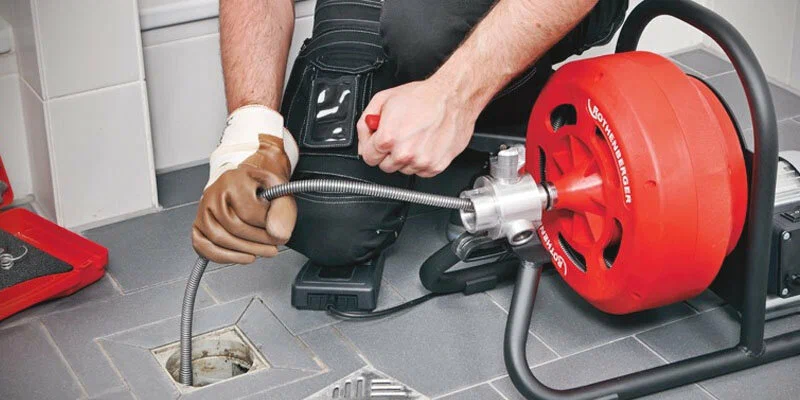 Plumber using a drain-cleaning machine in Miami Gardens