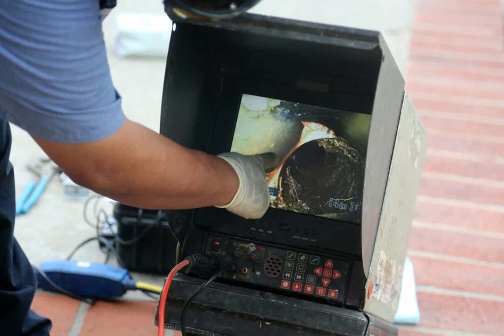 Technician viewing a drain inspection camera in Miami Gardens