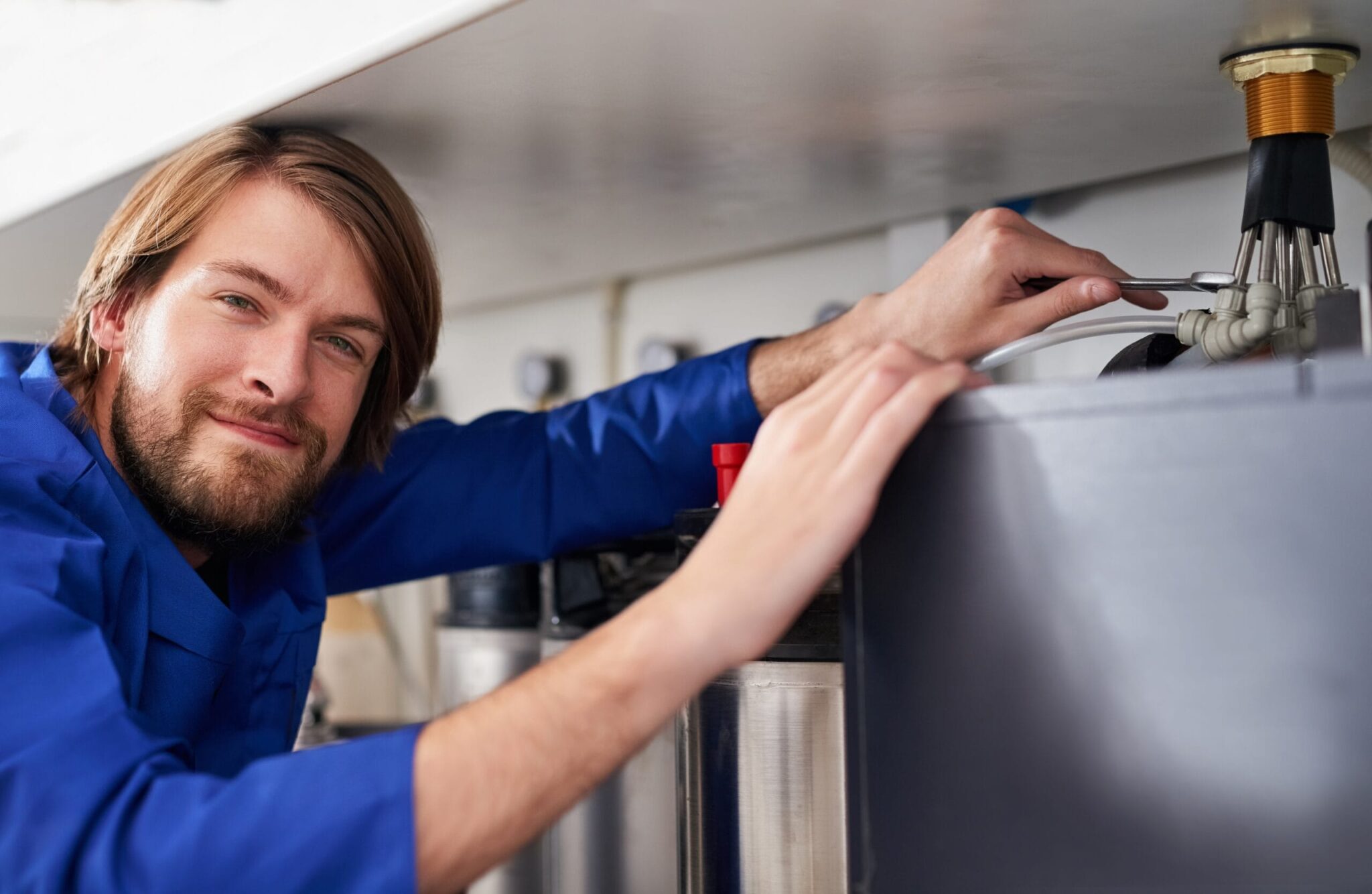 Technician servicing a residential water heater tank in Miami Gardens